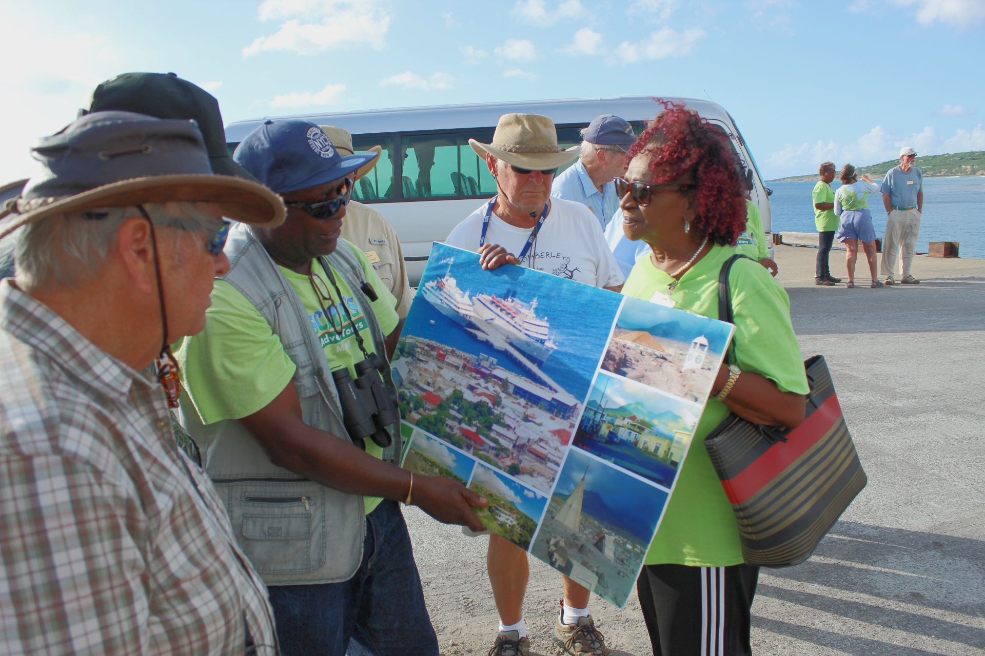 Scriber briefing cruise passengers at the pier with a photo board of Montserrat sights